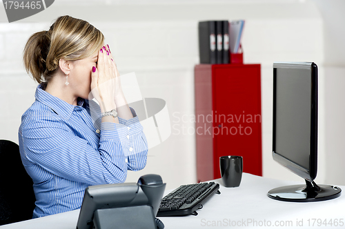 Image of Female secretary hiding her face with hands