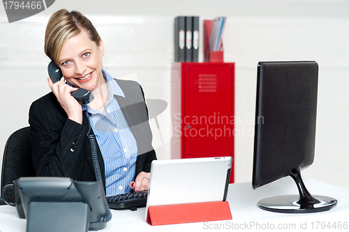 Image of Smiling female secretary attending phone call