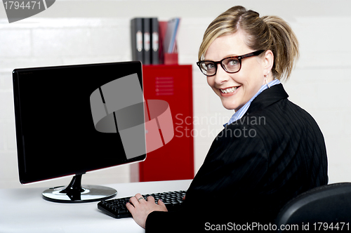 Image of Business lady turning back and smiling at camera