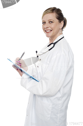 Image of Smiling aged surgeon holding pen and clipboard