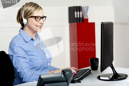 Image of Female executive taking instructions from clients
