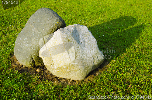 Image of Two big stones in meadow surrounded with cut grass 