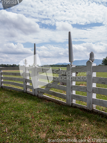 Image of White picket fence in garden to rural meadow