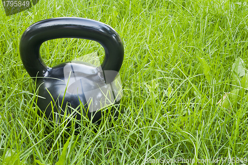 Image of heavy iron  kettlebell in grass