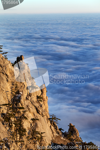 Image of Sunlit cliffs and sea in clouds