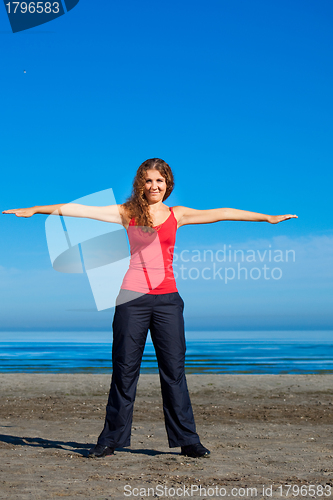 Image of girl doing morning exercises at the beach
