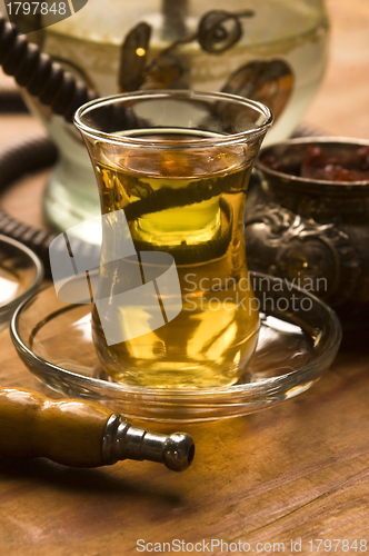 Image of Cup of turkish tea and hookah served in traditional style