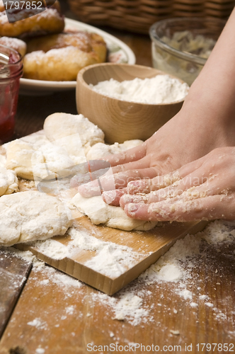 Image of Detail of hands kneading dough