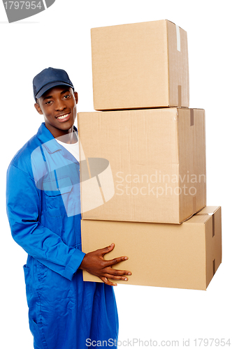 Image of Young delivery guy holding stack of parcel boxes