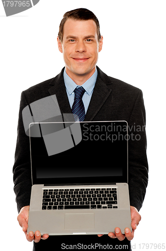 Image of Smart businessman displaying laptop to you
