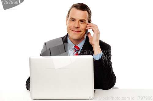 Image of Businessman working and talking on cell phone