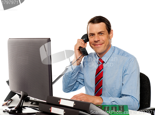 Image of Businessman talking on phone, handling clients