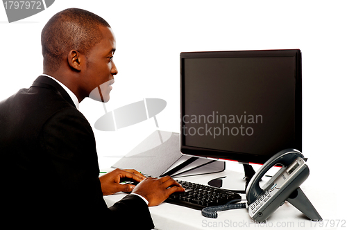 Image of Male executive typing and looking at lcd screen