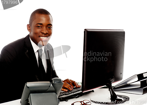 Image of Smiling young corporate man using computer