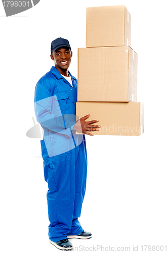 Image of Young delivery boy holding cardboard boxes