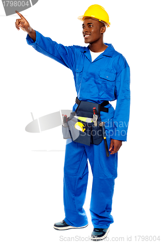 Image of Young african male worker pointing at copy space