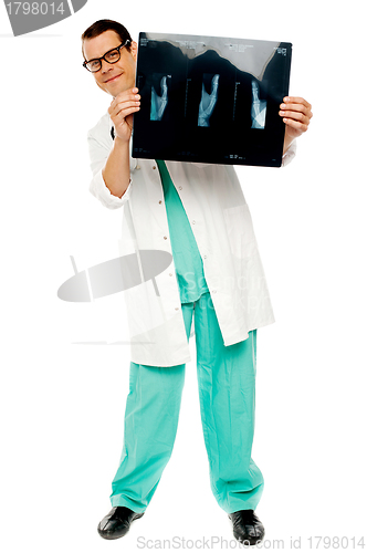 Image of Young surgeon showing x-ray report of patient