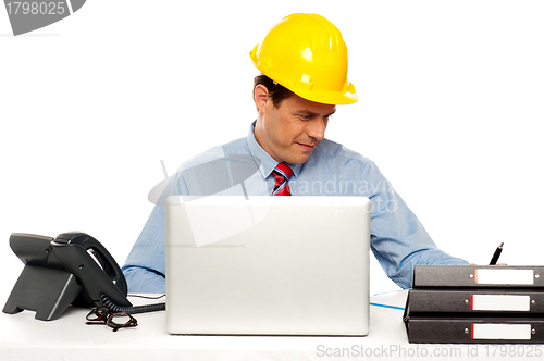 Image of Young architect actively working at his desk