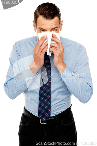 Image of Young man having severe cold. Sneezing