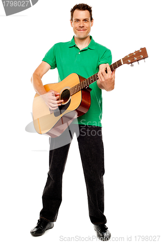 Image of Young caucasian guitarist playing tracks