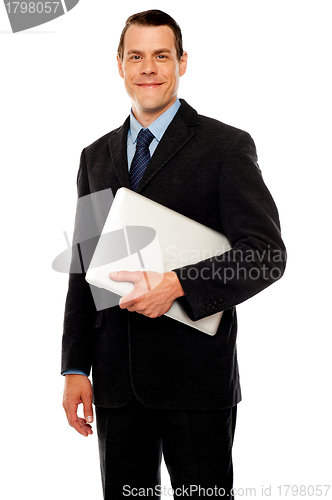 Image of Handsome business executive holding laptop