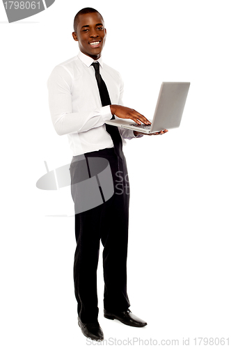Image of Full length portrait of businessperson holding laptop