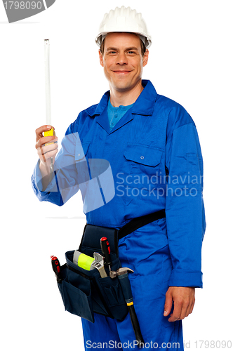 Image of Building worker holding measuring tape
