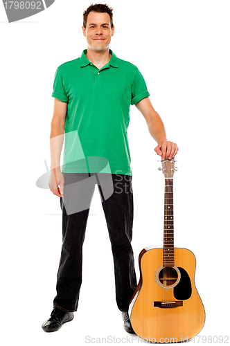 Image of Young guitarist standing with guitar