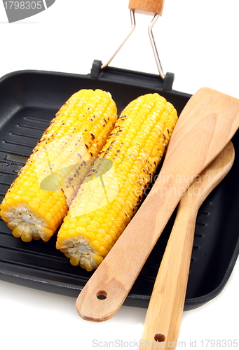 Image of Grilled corn and wooden spoon in the pan.