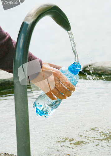 Image of fountain of spring water bottle filling holding hand in Lugano, 