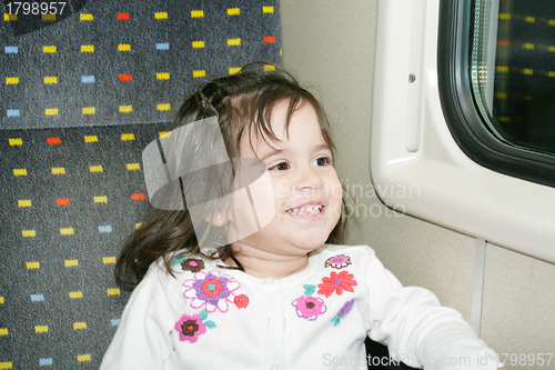 Image of Cute little girl looking window inside a moving train