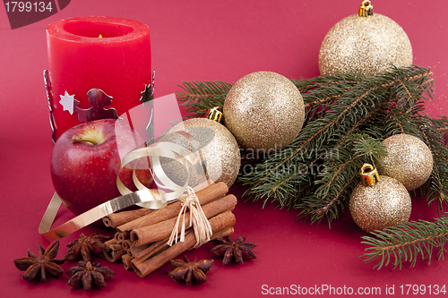 Image of christmas decoration red apple, cinnamon, anise and tree on red background