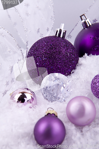 Image of beautiful christmas decoration in purple and silver on white snow