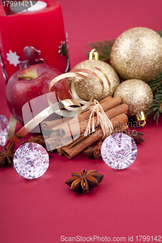 Image of christmas decoration red apple, cinnamon, anise and tree on red background