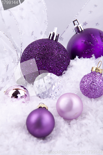 Image of beautiful christmas decoration in purple and silver on white snow