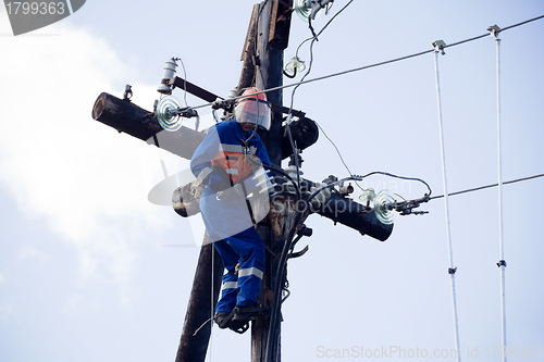 Image of Electric is working on a pole