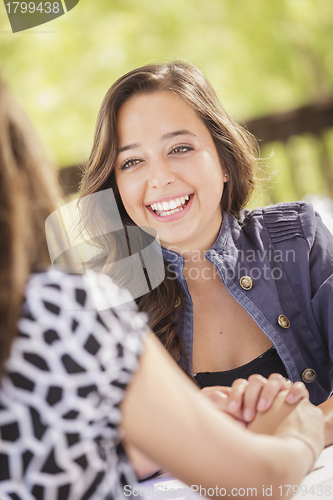 Image of Attractive Girlfriends Laughing Sitting Outside