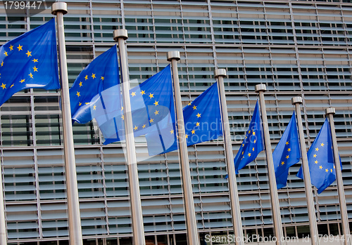 Image of European flags in front of the Berlaymont building, headquarters of the European commission in Brussels.