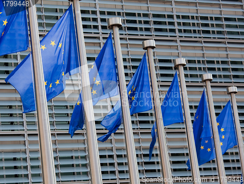 Image of European flags in front of the Berlaymont building, headquarters of the European commission in Brussels.