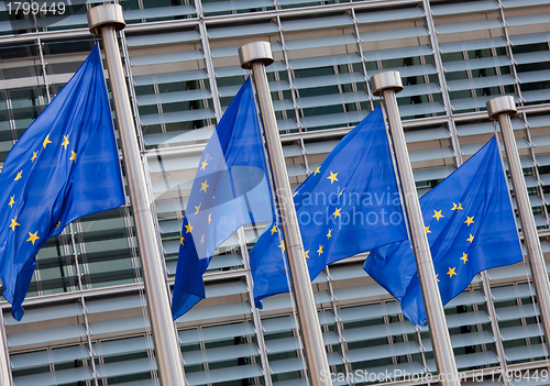 Image of European flags in front of the Berlaymont building, headquarters of the European commission in Brussels.