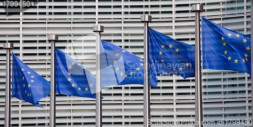 Image of European flags in front of the Berlaymont building, headquarters of the European commission in Brussels.