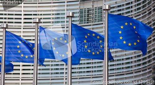 Image of European flags in front of the Berlaymont building, headquarters of the European commission in Brussels.