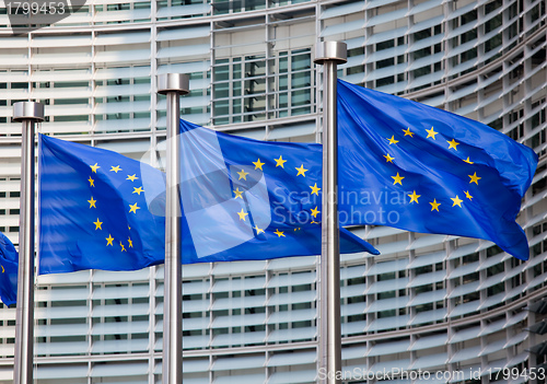 Image of European flags in front of the Berlaymont building, headquarters of the European commission in Brussels.