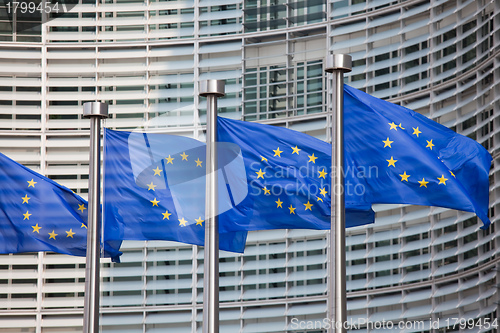 Image of European flags in front of the Berlaymont building, headquarters of the European commission in Brussels.