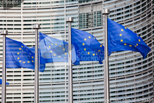 Image of European flags in front of the Berlaymont building, headquarters of the European commission in Brussels.