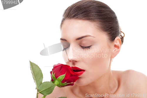 Image of woman holding and smelling red rose