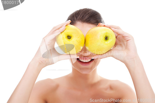 Image of woman holding apples over her eyes 