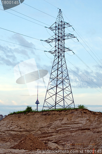 Image of High-voltage power poles wires television tower 