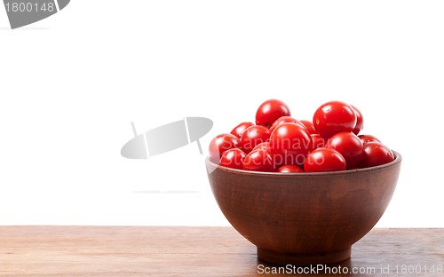 Image of Cherry tomato in ceramic bowl on wooden kitchen table