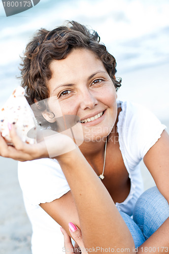 Image of woman on seacoast with a cockleshell